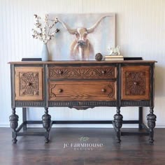 an ornate wooden sideboard with drawers and vases on it's top, in front of a white wall