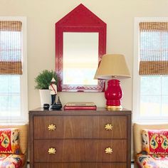 a dresser with a lamp and mirror on top of it