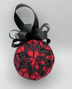 a red and black ornament hanging from a ribbon