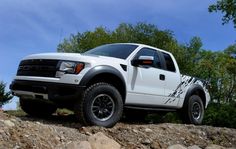 a white truck parked on top of a rocky hill