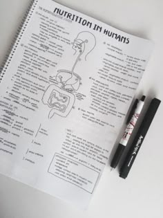 a notebook with instructions on how to use nutrition in humans and the human body, next to a marker