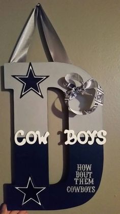 the letter j is made out of wood and has a star on it, which reads cow boys how bout them cowboys