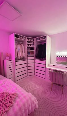 a bedroom with pink lighting and lots of closet space, including a dressing table in the corner