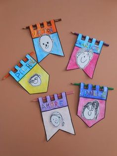 four children's clothes hanging from clothes pins with cartoon faces on them and the words happy mother written in different colors