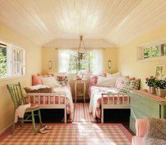 two beds in a room with pink and white checkered rugs on the floor