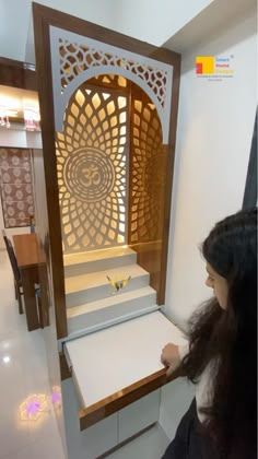 a woman standing in front of a display case with paper cutouts on the side