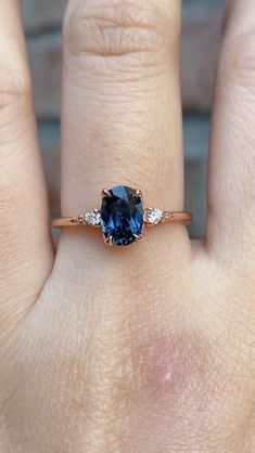 a woman's hand with a ring on it and a blue stone in the middle