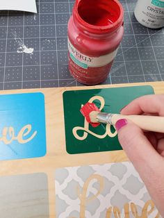 someone is painting the letters on wood with acrylic paint and a crayon