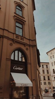 a tall building with a clock on the side of it's face and windows