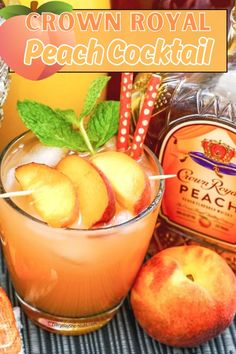 a glass filled with peach cocktail sitting on top of a table next to some fruit