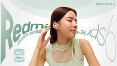 a woman with ear buds in front of a redmi bust 6 advertisment