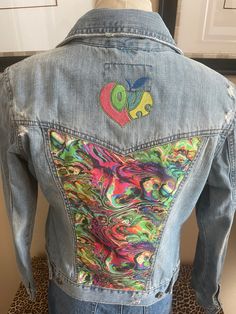 "Love and Peace Aeropostale distressed denim jacket is embellished with groovy psychedelic fabric on the back panel and above on the yoke is a \"love\" design that's colors complement the fabric. This jacket is distressed, the edges of the collar, pocket flaps, waistband, yoke, and hem are very raw that truly makes this jacket perfect for a Boho look.  Aeropostale Size M no fabric content label available Measurment's Chest 35\" Sleeve 23 3/4\" Shoulder 15 1/2\" Length 20 3/4\"" Multicolor Graphic Print Denim Jacket For Spring, Spring Hippie Denim Jacket, Fitted Distressed Cotton Denim Jacket, Fitted Cotton Denim Jacket With Patches, Trendy Festival Denim Jacket In Medium Wash, Trendy Medium Wash Denim Jacket For Festivals, Fitted Denim Jacket With Graphic Print In Medium Wash, Trendy Multicolor Cotton Denim Jacket, Trendy Cotton Denim Festival Jacket