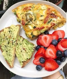 a plate with toast, strawberries and avocado on it