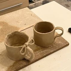 two coffee mugs sitting on top of a counter