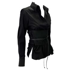 Presenting a stunning black collared Gucci belted shirt, designed by Tom Ford. From the Fall/Winter 2002 collection, this beautiful top features a plunging neckline, collar, and built-in wrap-around obi belt. The top is kept closed by the belt which is secured by a braided leather tie. Obi belts and Japanese influence were heavily present in this dark rocker-chic Gucci by Tom Ford collection, making this top a must-have! Approximate measurements: IT38 23.5" shoulder to hem 23" shoulder to cuff 18" armpit to cuff 3" collar 6" thick obi belt 29" long obi belt (not including braided leather) 100% cotton Elegant Gucci Luxury Shirt, Luxury Gucci Tops With Button Closure, Elegant Gucci Blouse For Evening, Elegant Gucci Blouse For Party, Gucci Collared Blouse For Formal Occasions, Gucci Luxury Formal Blouse, Luxury Gucci Blouse For Formal Occasions, Luxury Formal Gucci Blouse, Luxury Formal Blouse By Gucci