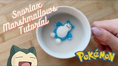 someone is holding a cup with a small blue cat in it and the words pokemon are on