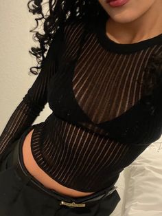 a woman with long black hair wearing a sheer top