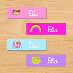 three name tags with cartoon characters on them sitting on top of a wooden table next to each other