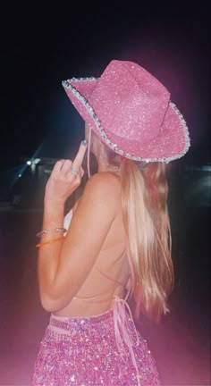 a woman wearing a pink hat while talking on her cell phone