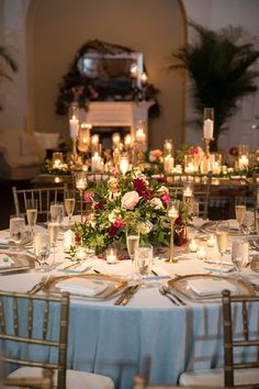 the table is set with candles, flowers and wine glasses for an elegant wedding reception