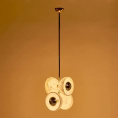 three rolls of toilet paper sitting on top of a light fixture hanging from a ceiling