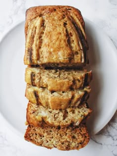 slices of banana bread stacked on top of each other in a white plate with marble background