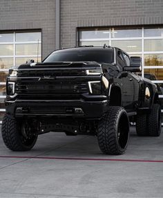 a large black truck parked in front of a building