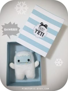 a small white stuffed animal in a blue box