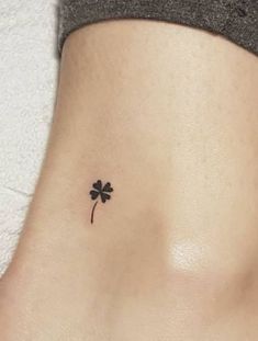 a small four leaf clover tattoo on the side of a woman's stomach,