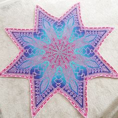 a blue and pink star shaped object on a white surface with other items in the background