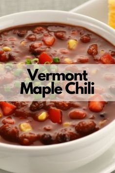 a bowl of vermont maple chili on a white plate with cornbreads in the background