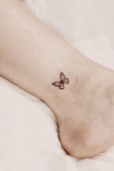 a small butterfly tattoo on the left side of the foot is shown in black and white