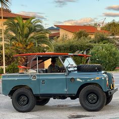 an old blue truck with a surfboard on top