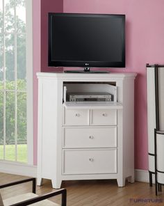 a flat screen tv sitting on top of a white dresser next to a pink wall