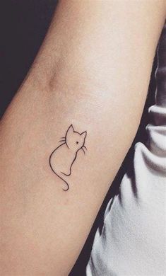 a small cat tattoo on the arm