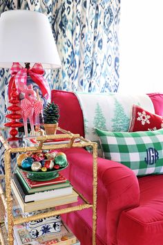 a living room with red couches and christmas decorations on the table next to it