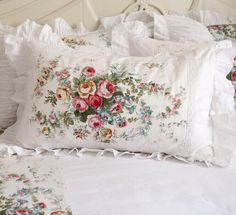 a white bed topped with lots of pillows