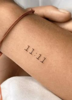 a woman's arm with the word lil written on it, and an arrow tattoo