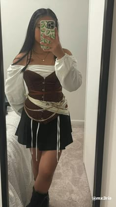 a woman taking a selfie in a mirror wearing a corset and skirt