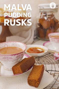 two pieces of bread sit on a plate next to cups and saucers with jams in the background