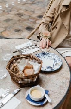 a person sitting at a table with food and wine