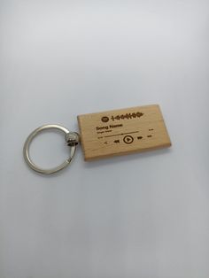 a wooden keychain with an electronic device engraved on the front and back side