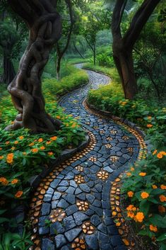 a pathway in the middle of a lush green forest with flowers growing on both sides