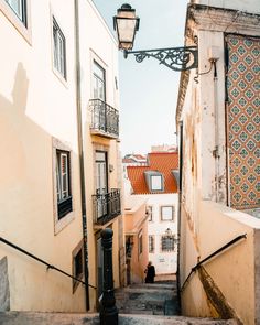 an alleyway with stairs leading up to some buildings and a street light in the distance