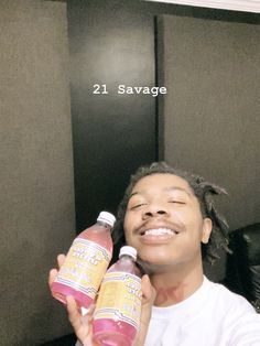 a man holding two bottles of juice in front of his face with the caption 21 savge