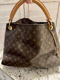 Introducing the beautiful and stylish Louis Vuitton Artsy Shoulder Bag MM in brown monogram canvas. This large-sized shoulder bag features a spacious interior lined with soft microfiber, gold-tone hardware, and a comfortable leather strap with a 2.7-inch drop. This bag is perfect for any occasion, whether it's a casual outing or a night out on the town. The open/no closure design provides easy access to your belongings, and the versatile beige handle/strap color complements any outfit. Add the Louis Vuitton Artsy Shoulder Bag MM to your collection today! This bag is in fantastic condition on the outside there are no cracks on the top or any on the corners. The only 2 flaws is the strap has a few marks on it and the inside has a few stains. All of this is in the photos. Any questions feel f Louis Vuitton Handbags Outlet Cheap, Replica Louis Vuitton Handbags, New Louis Vuitton Handbags, Vintage Louis Vuitton Handbags, Louis Vuitton Handbags Outlet, Louis Vuitton Artsy Mm, Mm Monogram, Louis Vuitton Artsy, Closure Design