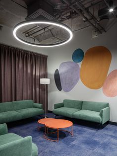 a living room with couches, chairs and a coffee table in front of a painting on the wall