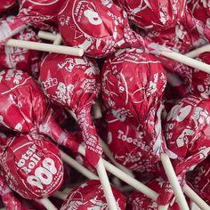 a pile of red and white lollipops sitting on top of each other