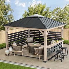 a gazebo sitting on top of a wooden deck next to a table and chairs