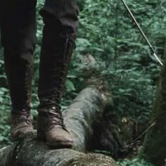 a person standing on top of a log in the woods